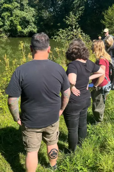 Teilnehmer der Kräuterwanderung begutachten den Fluss und die Kräuterpflanzen.