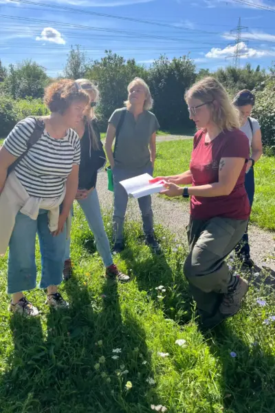 Naturkunde bei der Kräuterwanderung im Saarland. Julia erklärt den Teilnehmern die Vielfalt der Natur.